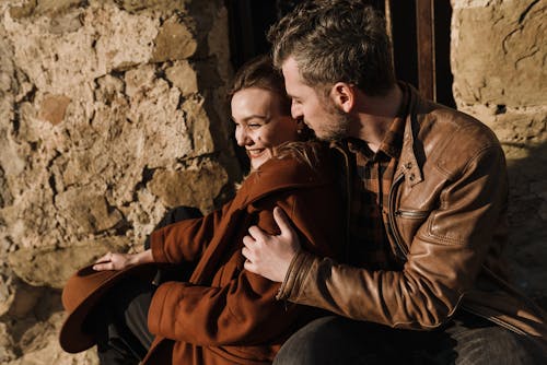 Man in a Brown Leather Jacket with a Woman in a Brown Coat