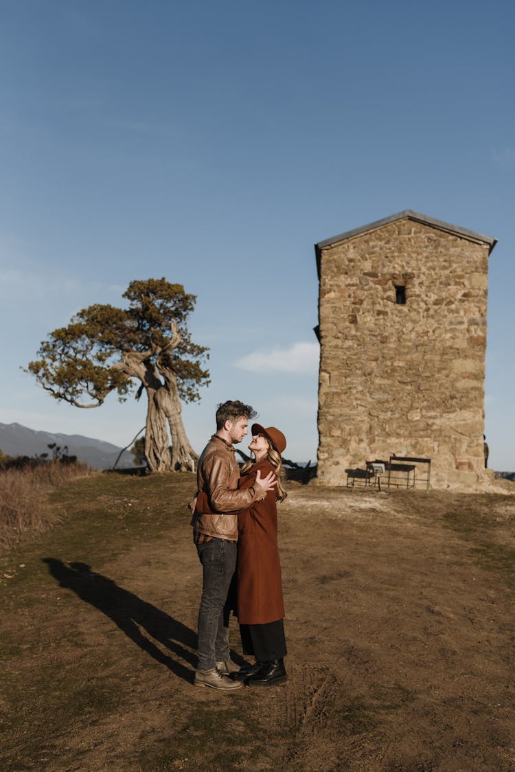 Man And Woman Standing Near Brown Building