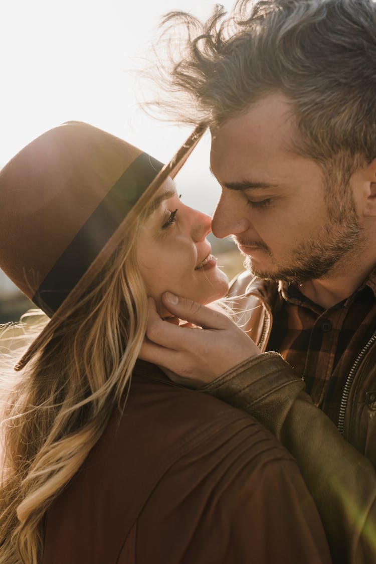 Man Kissing A Woman Wearing Brown Fedora Hat