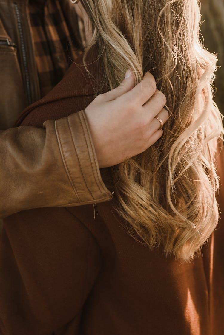 Man In Brown Leather Jacket Touching A Blonde Hair