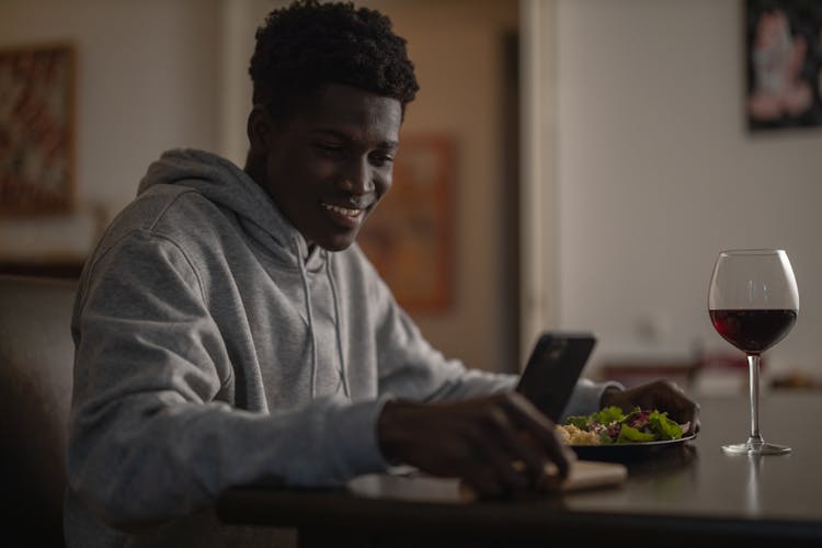 Man On His Phone While Eating