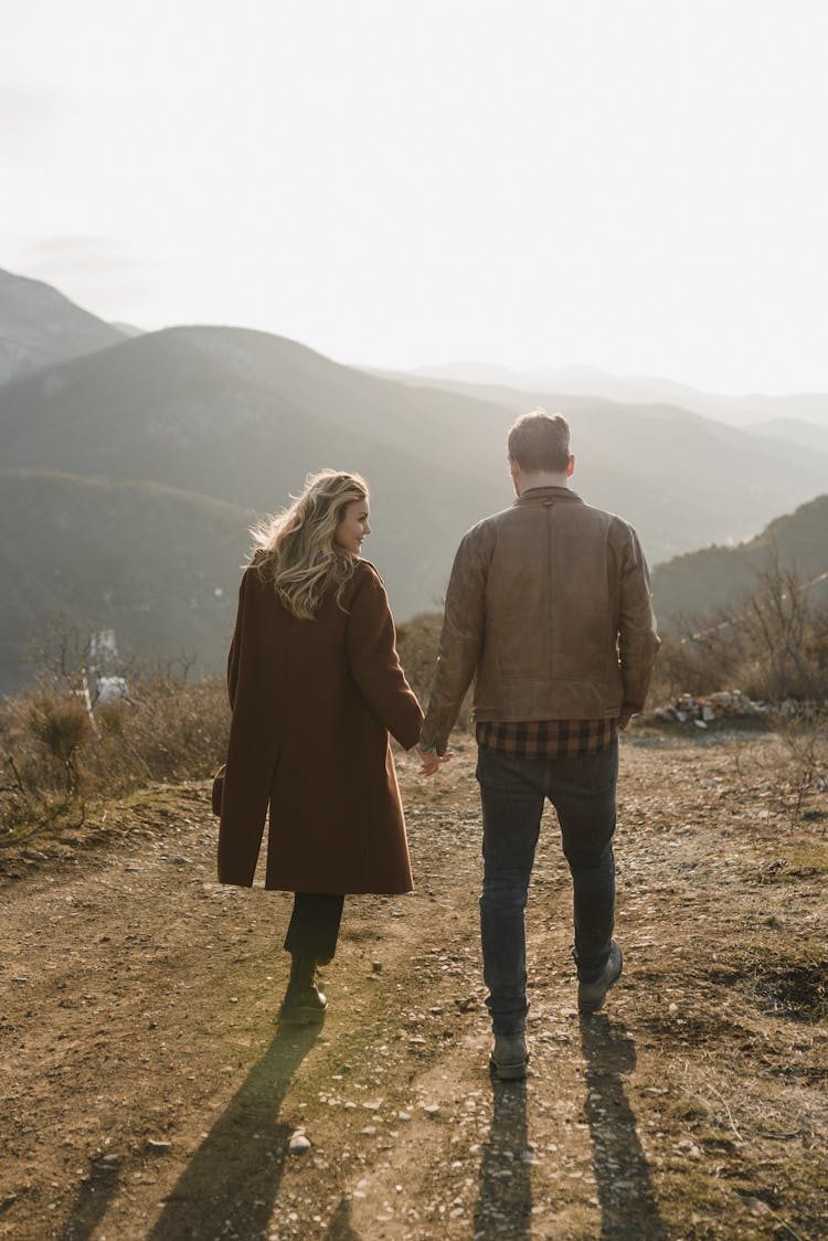 Couple Walking Holding Hands In Mountain Landscape