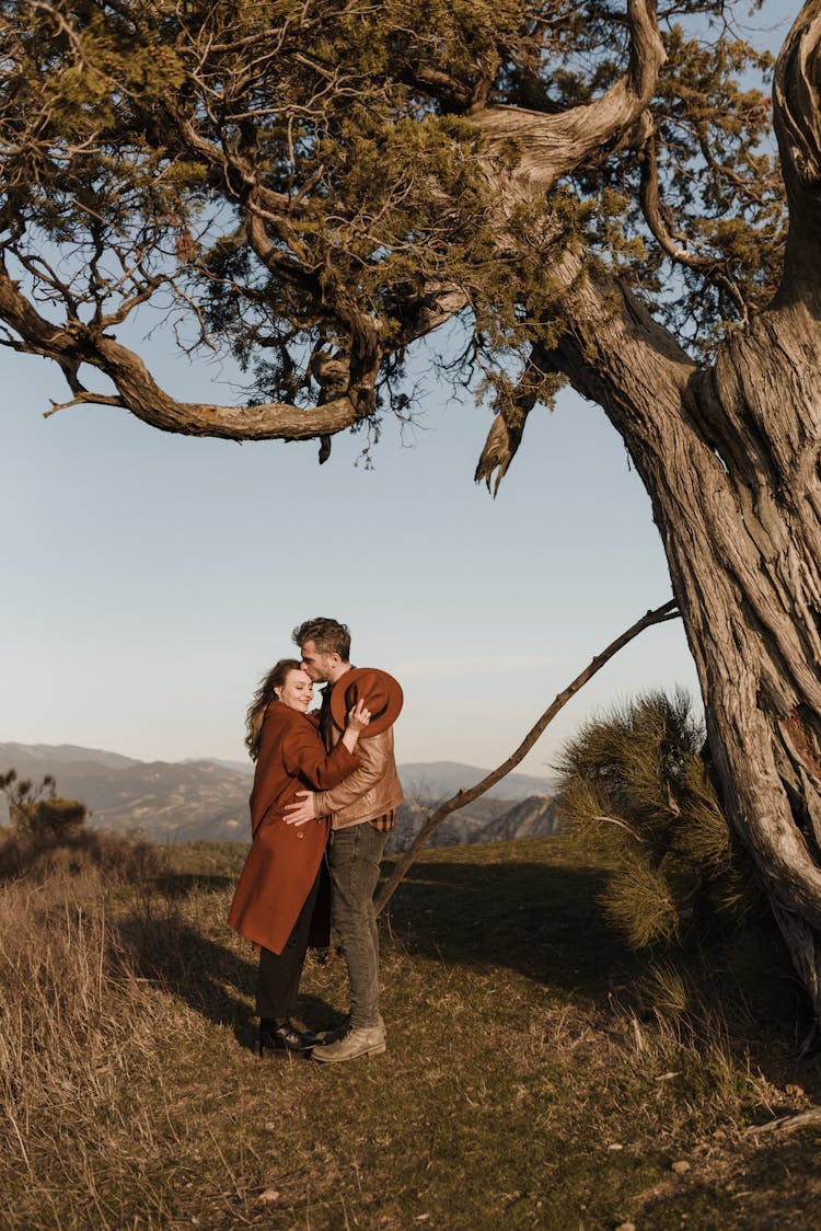 Man And Woman Standing Under A Tree