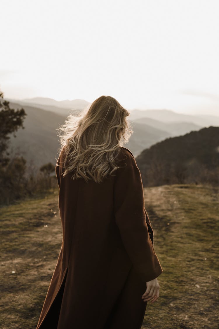 Woman Standing On Top Of Hill