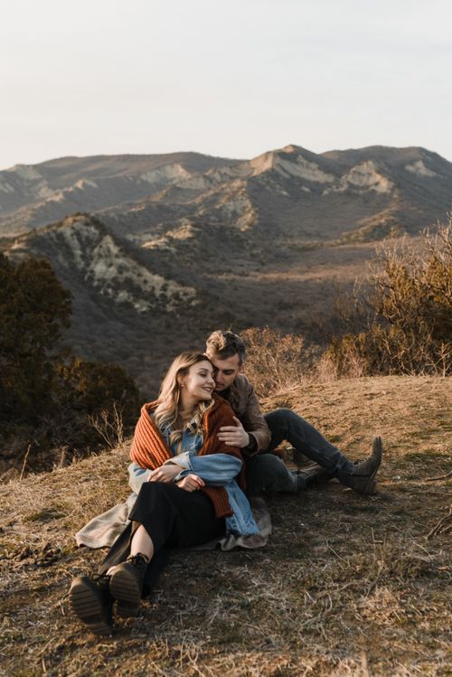 Free A couple enjoying a serene moment together on a picturesque mountain hillside. Stock Photo