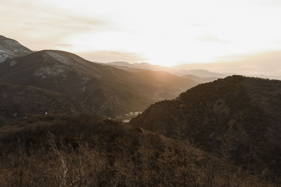 Peaceful mountain valley at sunset with soft light and natural scenery.