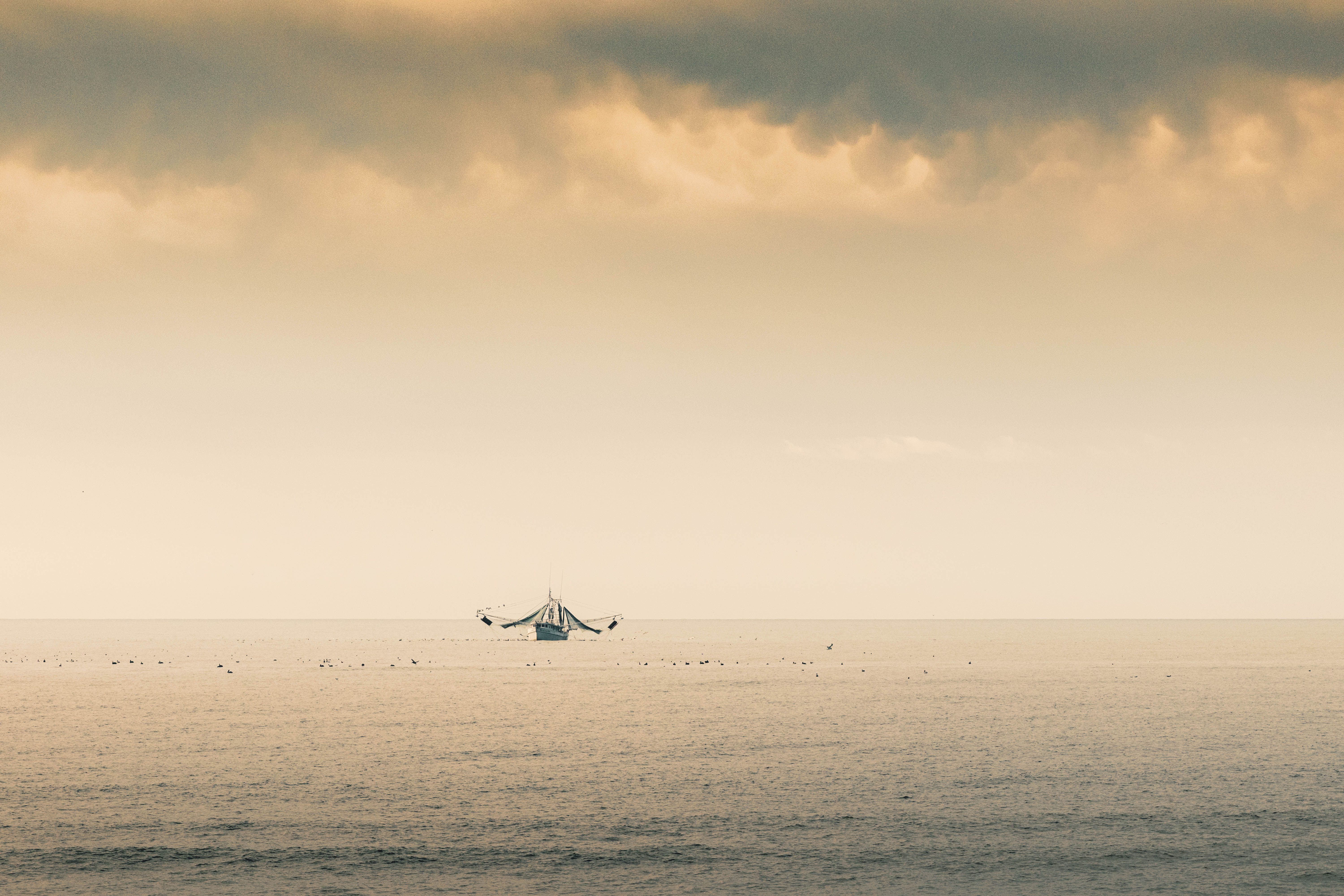 A Boat on Sea Under Cloudy Sky · Free Stock Photo