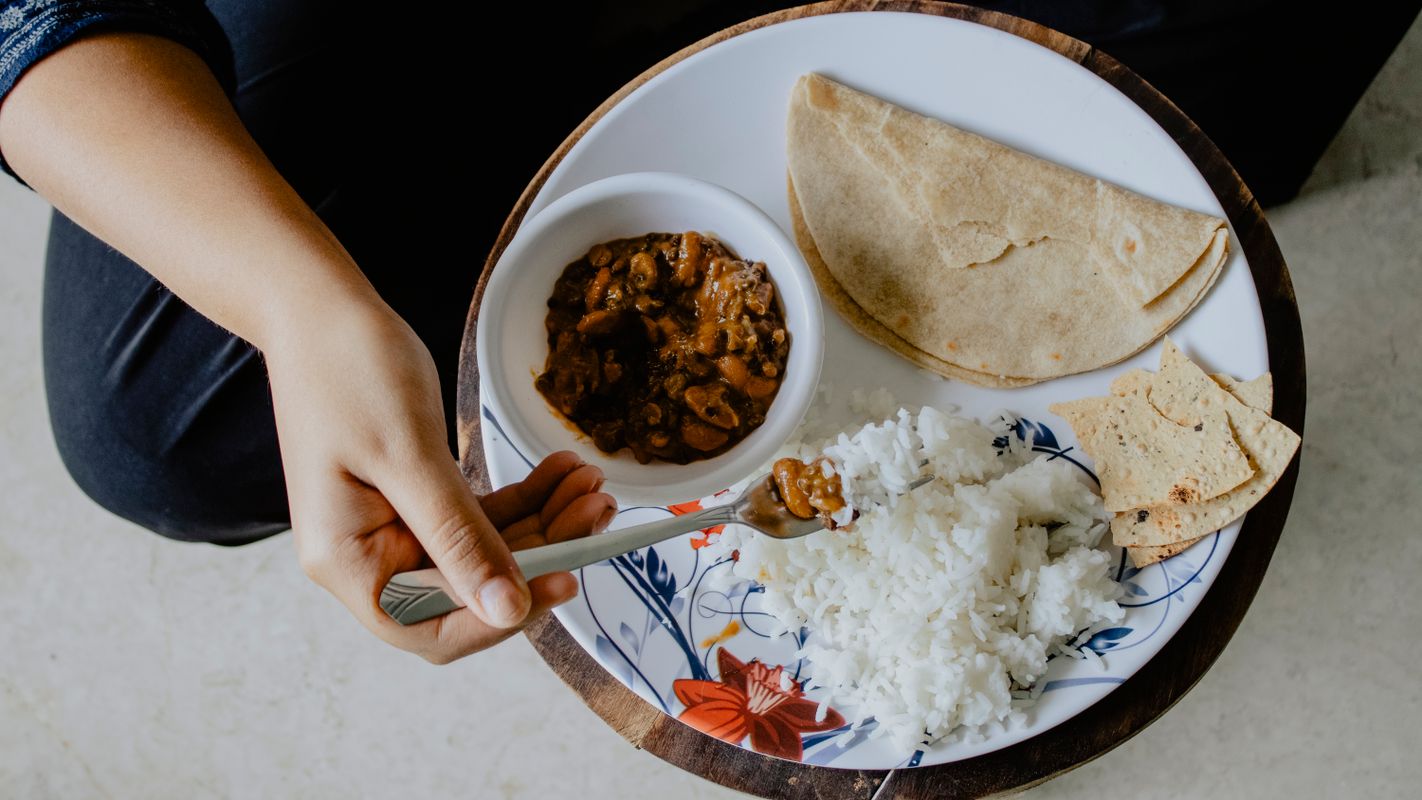 hands tearing roti with ghee