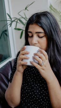 Young woman savoring coffee indoors, a calming and peaceful setting.