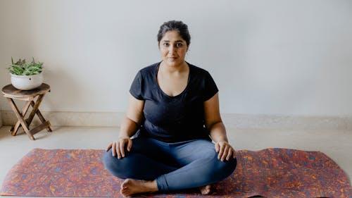 A Woman Sitting on the Yoga Mat