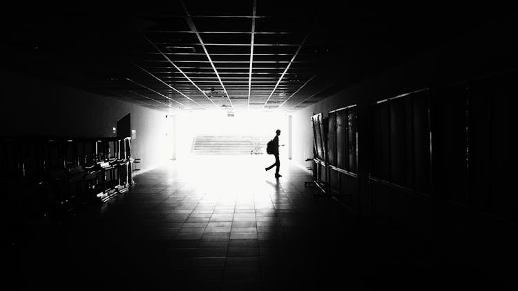 Silhouette Of Man Walking On Hall