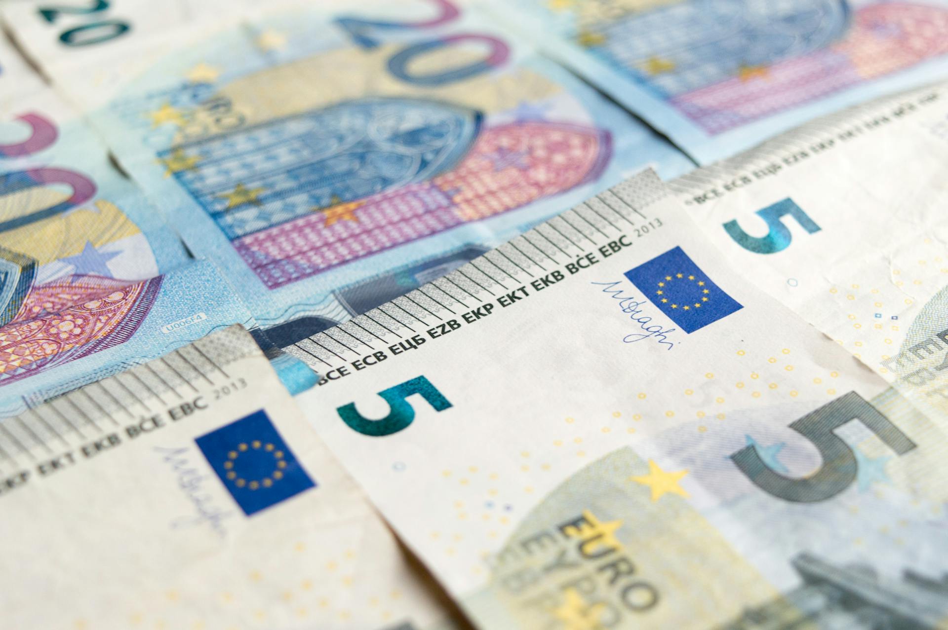 Detailed view of 5 and 20 euro banknotes showcasing European currency design.