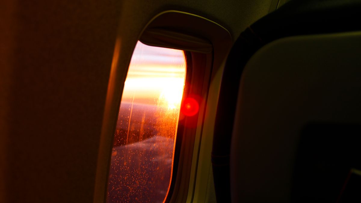 A stunning sunset view from an airplane window showcasing vivid skies and glowing horizon.