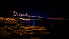 陶尔米纳海岸线的夜间景观令人惊叹，城市灯光倒映在大海中