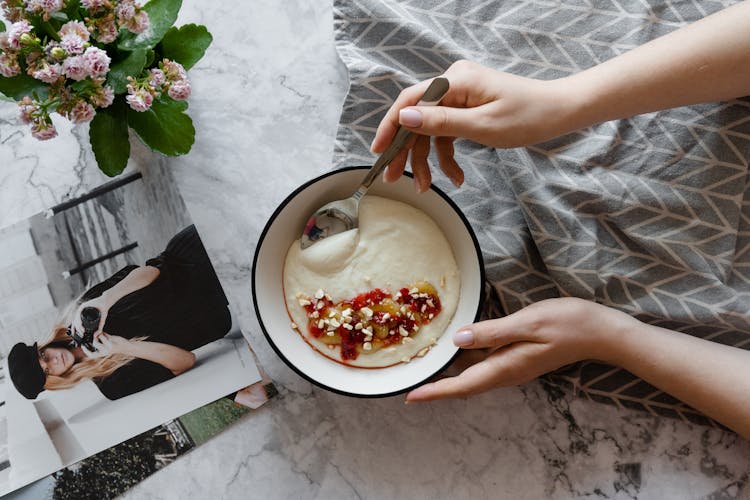 A Person Eating A Bowl Of Wheat Porridge