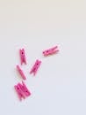在原始的白色背景上，散落着粉红色的衣夹