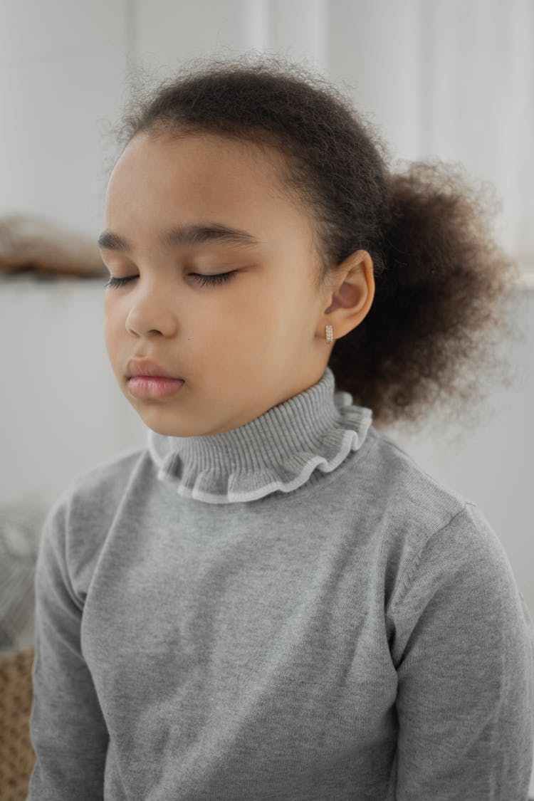 Cute Ethnic Kid Practicing Meditation With Closed Eyes