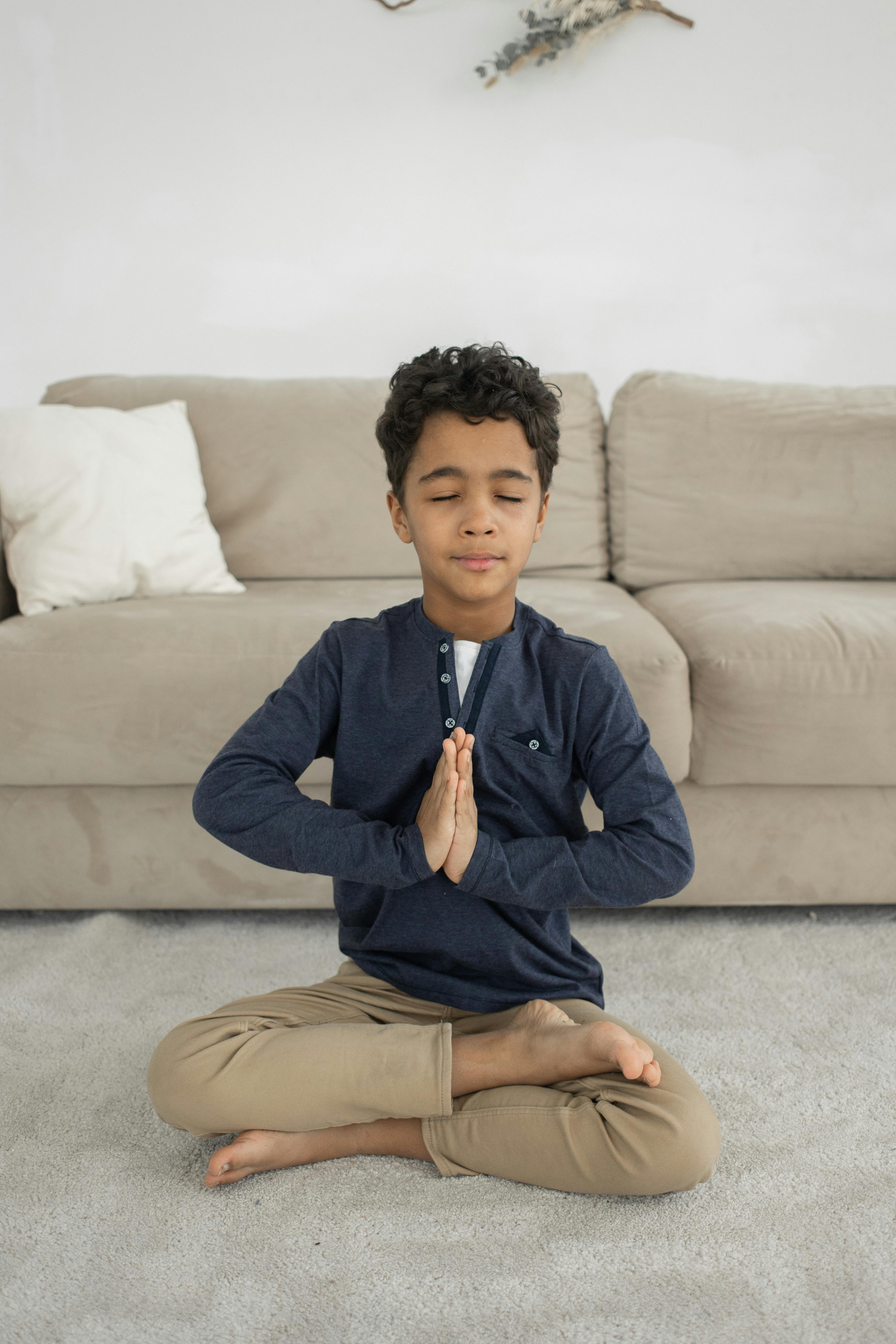 Cute African American child meditating with closed eyes on bed · Free ...