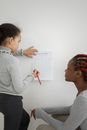 Black mother with daughter taking notes on paper