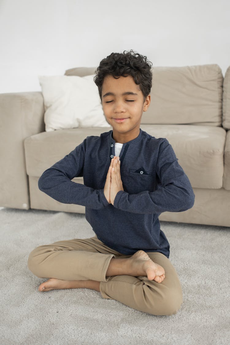 Happy Boy Meditating In White Room