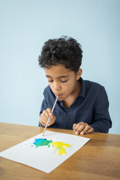 Adorable child drawing with aquarelle