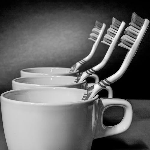 Free Toothbrushes in White Ceramic Mugs Stock Photo