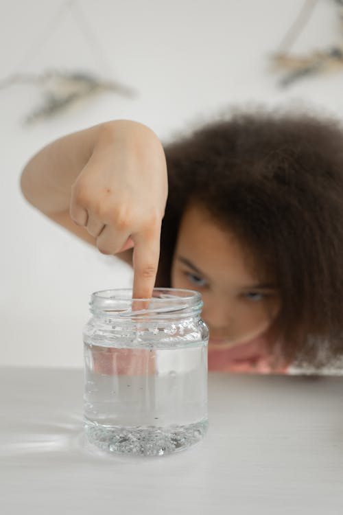 Free Concentrated black kid doing experiment with transparent slime Stock Photo