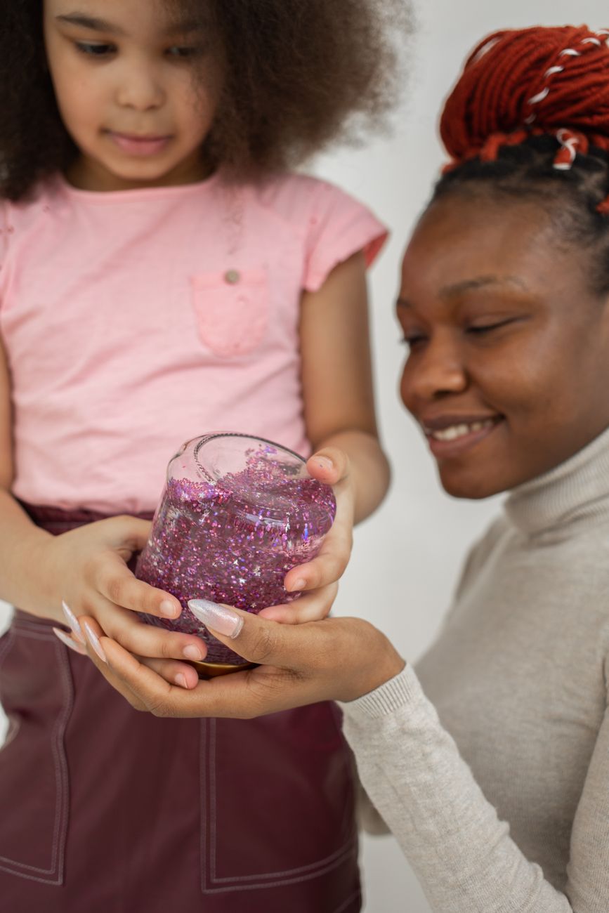 Mother and daughter happily creating colorful slime together