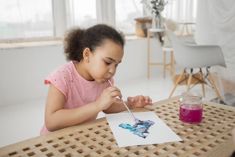 Creative Black Little Child Blow Painting With Straw On Paper