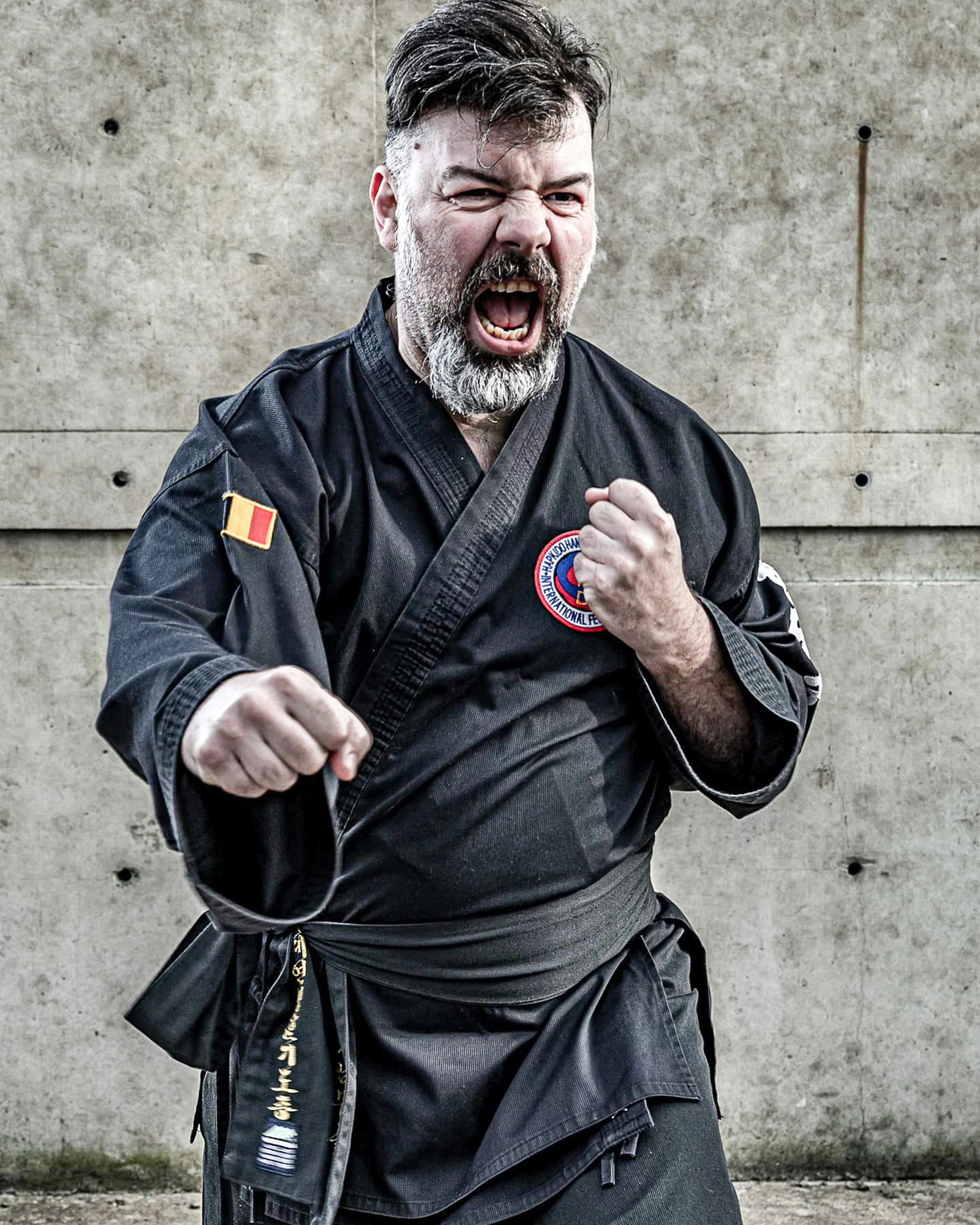 Close-up of a bearded man in martial arts gi showing fierce expression.