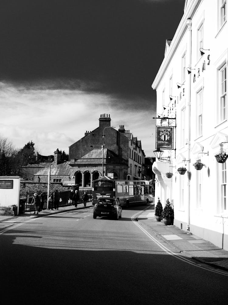 Old Town Street With Driving Cars And Walking Pedestrians