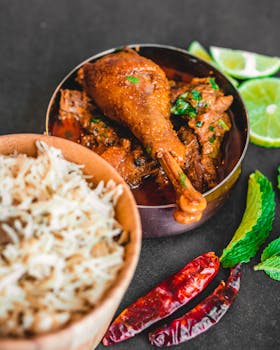 A flavorful Indian chicken curry served with rice, spices, and fresh lime for a vibrant meal.