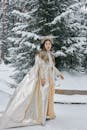 Woman in Brown Coat Standing on Snow Covered Ground