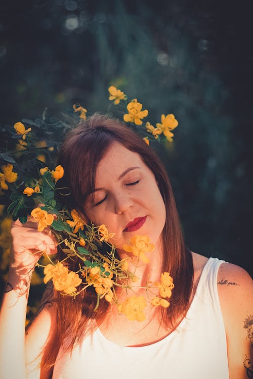 Free Woman in White Tank Top Holding Yellow Flower Stock Photo