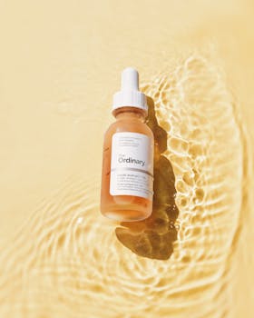Lactic acid serum bottle on rippling water background, perfect for skincare advertising.