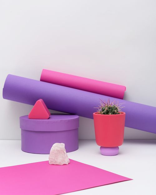 Free Vibrant minimalist setup with a cactus in a pot surrounded by colorful geometric shapes and textures. Stock Photo