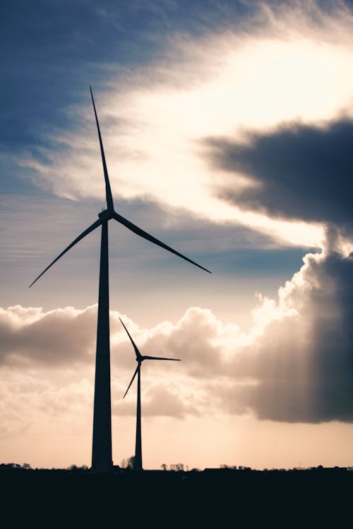 Силуэтное фото двух ветряных мельниц во время Золотого часа