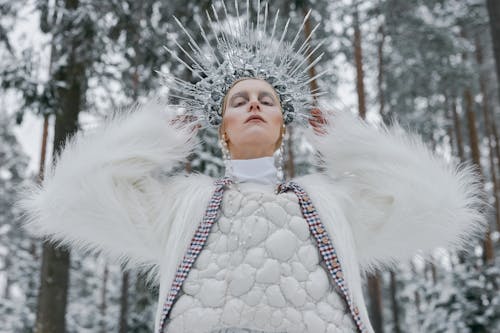 A Woman with a Crown Wearing White Dress and Fur Coat