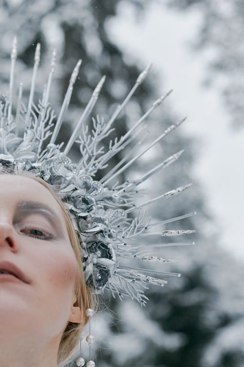 Free Portrait of a model with an ornate ice crown in a snowy forest setting. Stock Photo