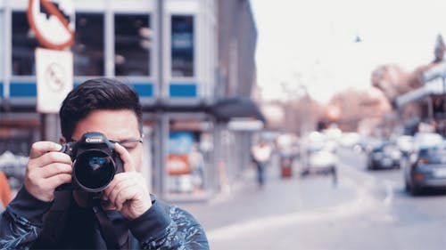 Free Man Holding A Camera On Busy Street Stock Photo