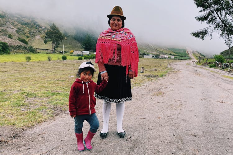 Woman In Traditional Clothing Holding Daughters Hand