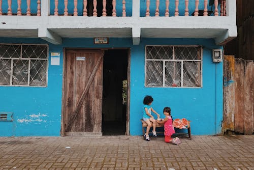 Children Playing on a Bench in Front of a Building