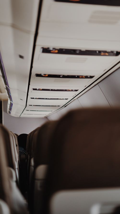 Free Close-up view of airplane seats and overhead compartments in a passenger cabin. Stock Photo