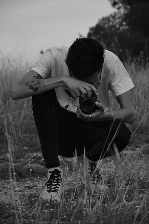 Grayscale Photo of a Man Taking Photo with a Camera