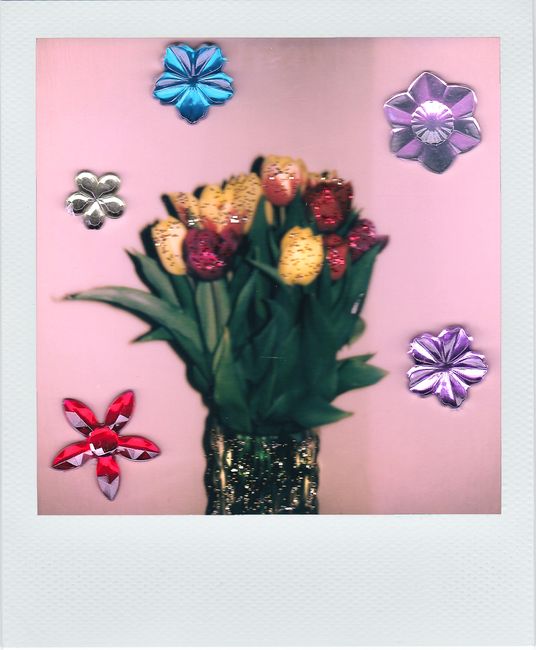 Vibrant tulip bouquet surrounded by glittery floral stickers on a pink background.