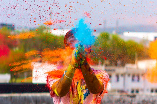 Colorful Holi festival celebration with vibrant powders thrown in the air creating a lively scene.