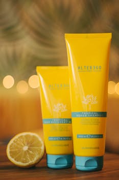 Yellow shampoo bottles with lemon slice on warm background, perfect for cosmetic advertising.