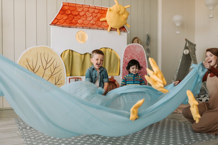 Happy Woman Playing With Toddlers 