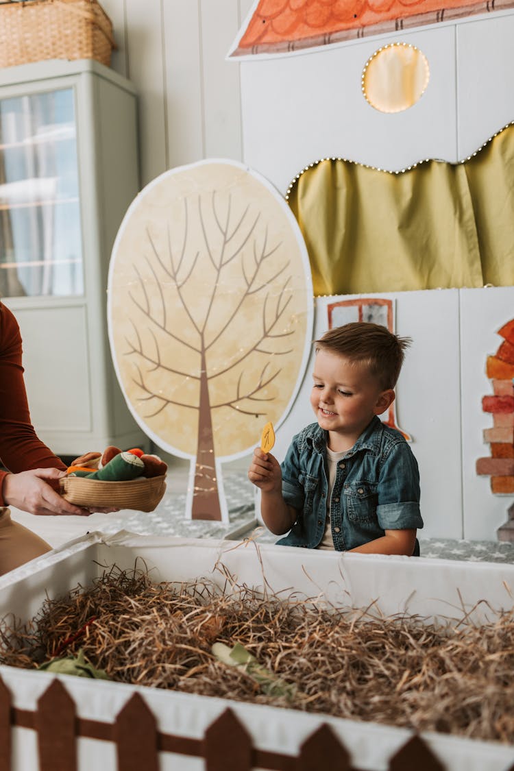 A Boy Holding A Leaf Cutout