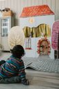 A Boy in Striped Shirt Sitting Watching a Puppet Theater